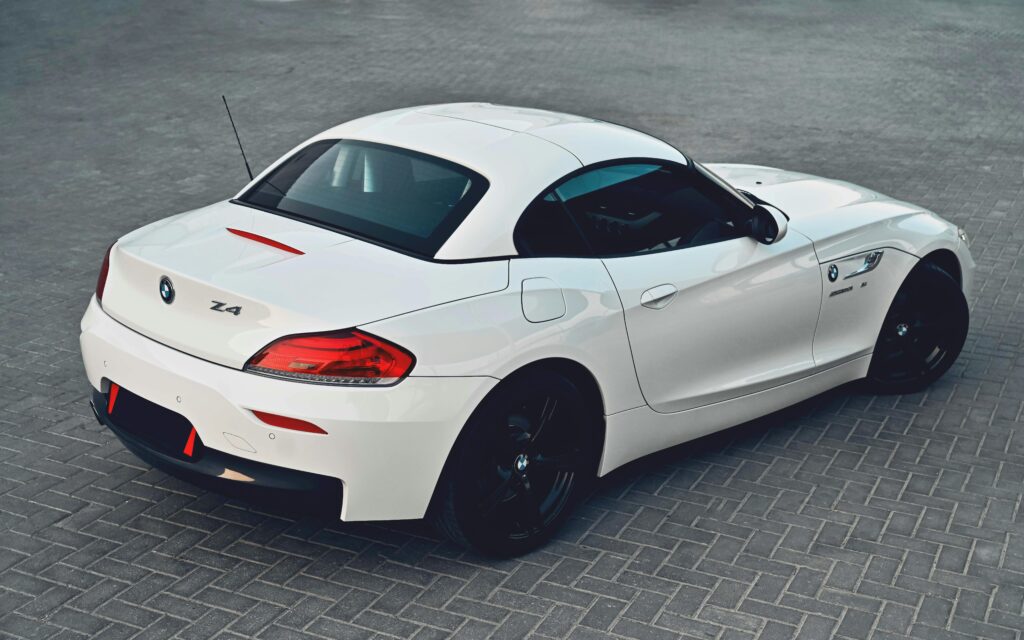 A sleek white BMW Z4 sports car parked on paved ground outdoors.