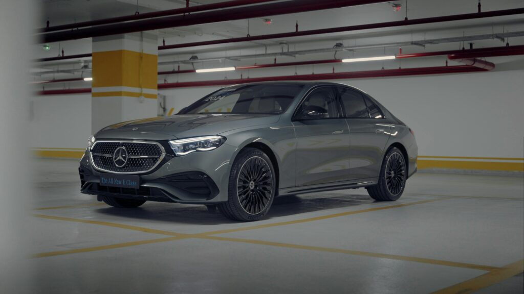 A sleek Mercedes-Benz E-Class car parked in an indoor parking garage with elegant lighting.